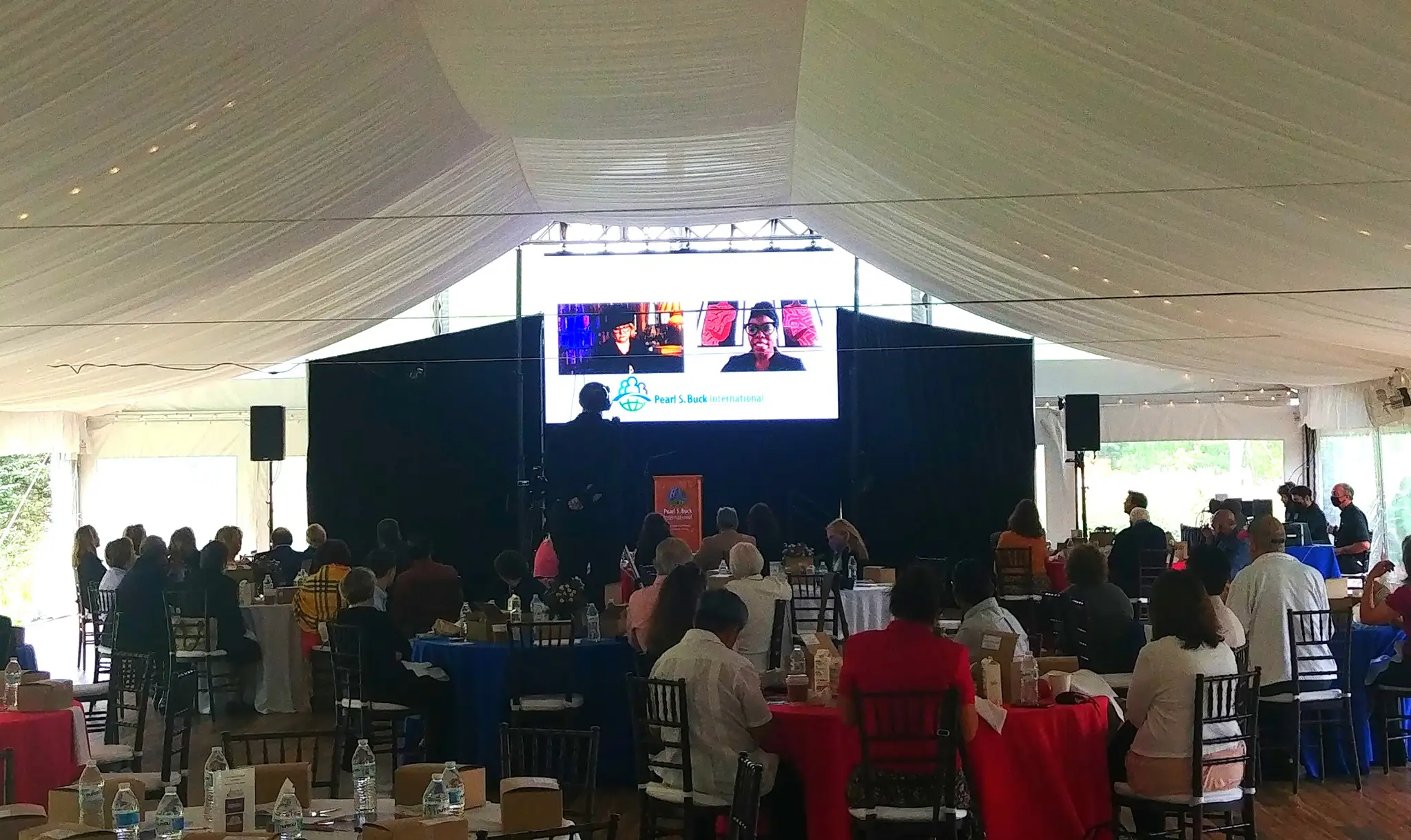 Projection screen inside of tent at Living the Legacy fundraiser