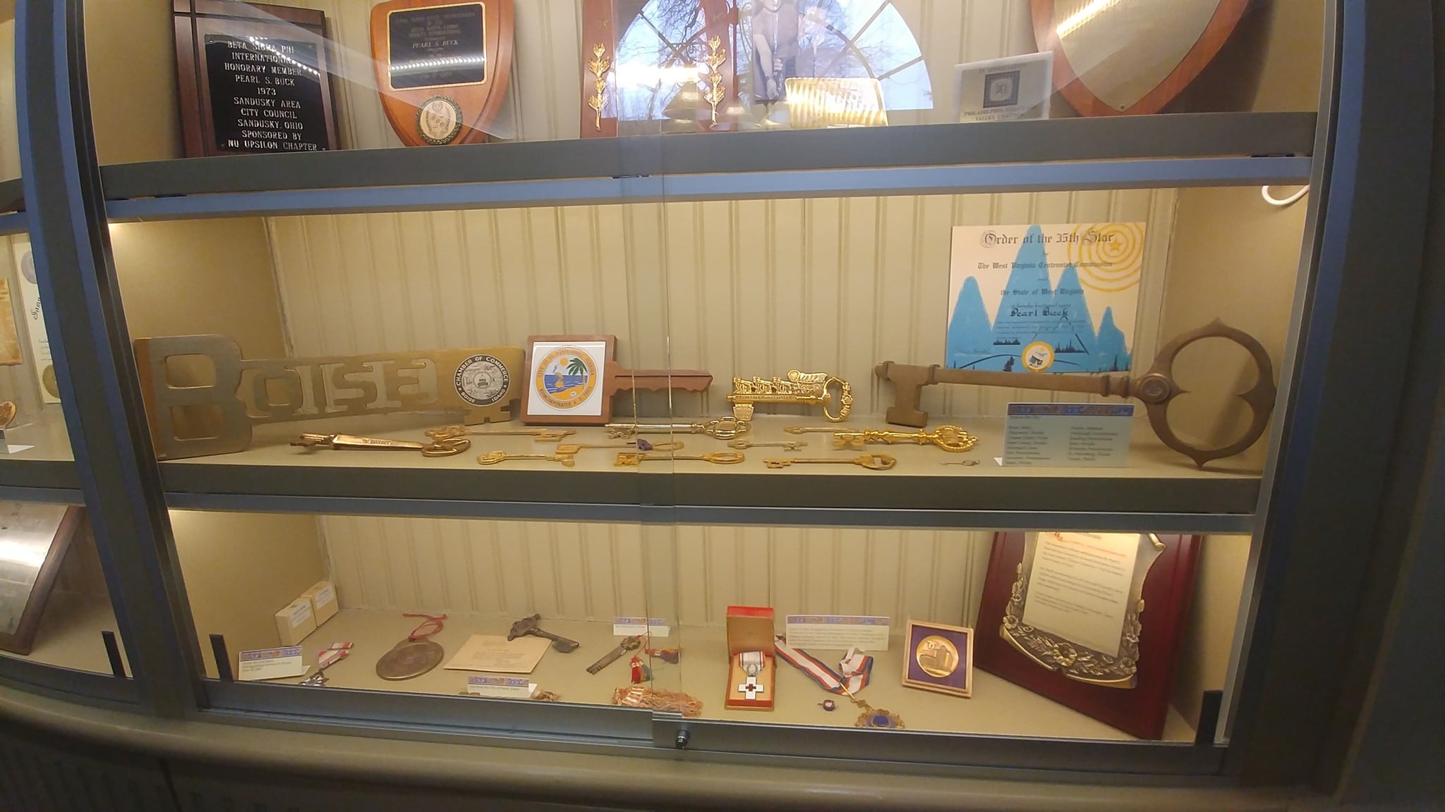 Pearl Buck awards exhibit with plaques, keys, and medals