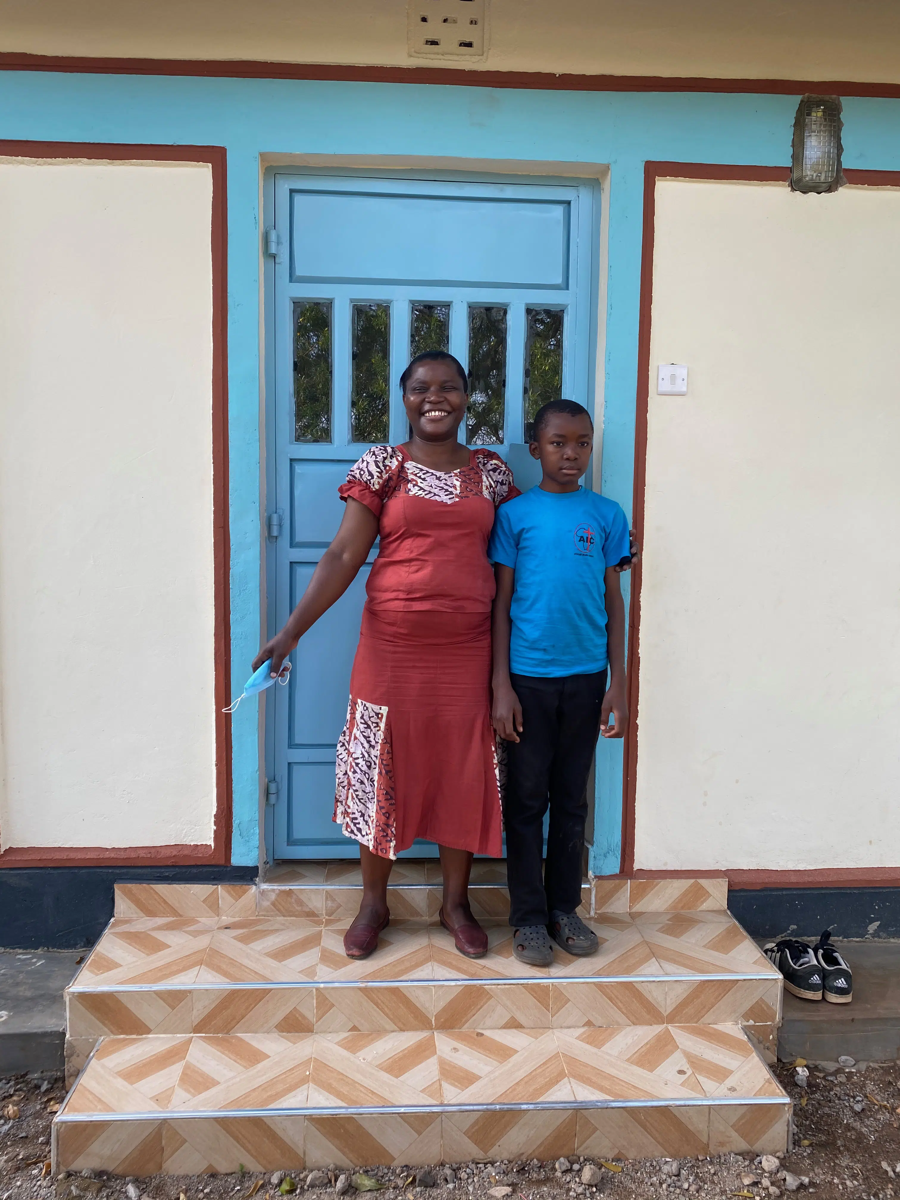 Family in Kenya standing in front of their house
