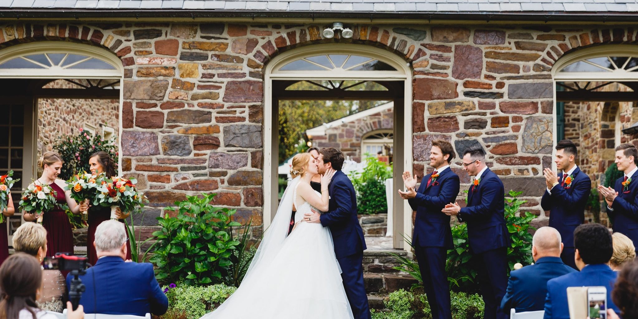 Bride and groom kiss outside Pearl Buck House